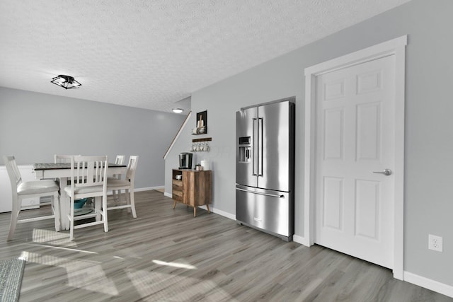 dining space featuring hardwood / wood-style flooring and a textured ceiling