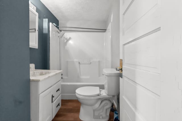 full bath featuring bathtub / shower combination, toilet, vanity, a textured ceiling, and wood finished floors