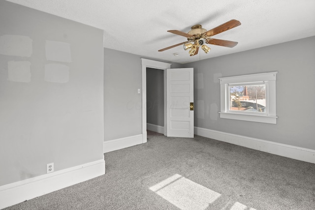 unfurnished room featuring a ceiling fan, carpet, a textured ceiling, and baseboards