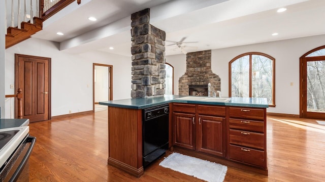 kitchen featuring sink, hardwood / wood-style flooring, ceiling fan, black dishwasher, and kitchen peninsula