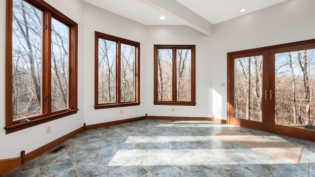 unfurnished sunroom with beamed ceiling and french doors