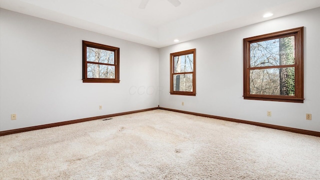 carpeted spare room featuring ceiling fan