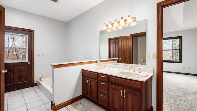 bathroom with vanity, a tub to relax in, tile patterned floors, and a healthy amount of sunlight