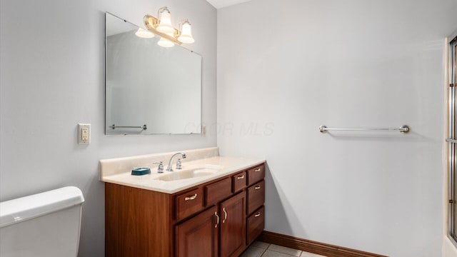 bathroom with tile patterned flooring, vanity, and toilet