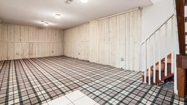 interior space featuring wood walls and a textured ceiling