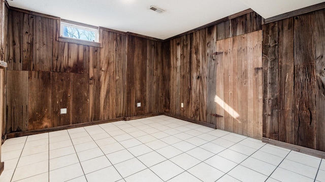 tiled empty room featuring wooden walls