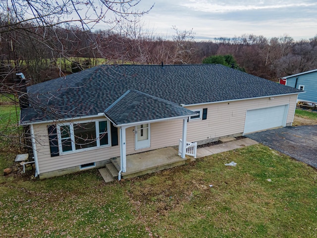 back of property featuring a lawn and a garage