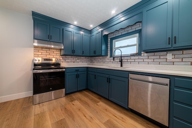 kitchen with appliances with stainless steel finishes, blue cabinets, and sink