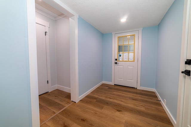 doorway to outside featuring a textured ceiling and hardwood / wood-style flooring