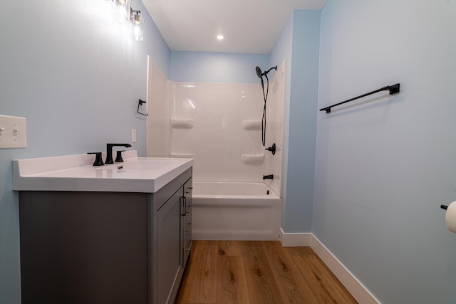 bathroom featuring hardwood / wood-style floors, vanity, and washtub / shower combination