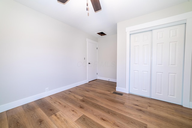 unfurnished bedroom featuring hardwood / wood-style floors, ceiling fan, and a closet