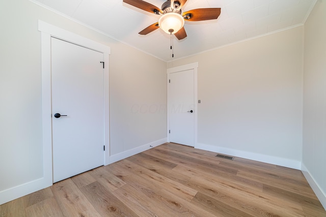 spare room featuring ceiling fan, light wood-type flooring, and crown molding