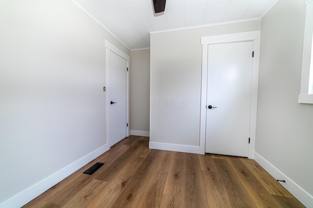 unfurnished bedroom featuring ceiling fan, dark wood-type flooring, and ornamental molding