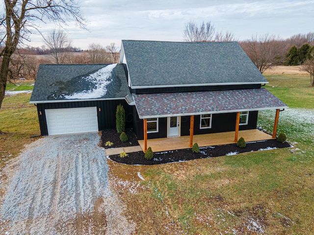 view of front of home with covered porch, a garage, and a front yard