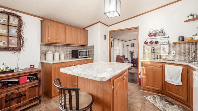 kitchen featuring a center island, lofted ceiling, backsplash, sink, and ornamental molding