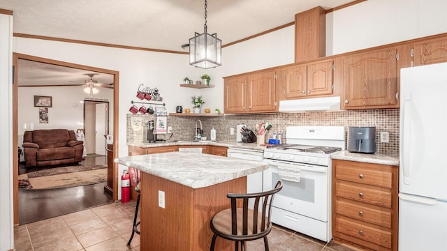 kitchen with white appliances, decorative light fixtures, a breakfast bar area, a center island, and lofted ceiling