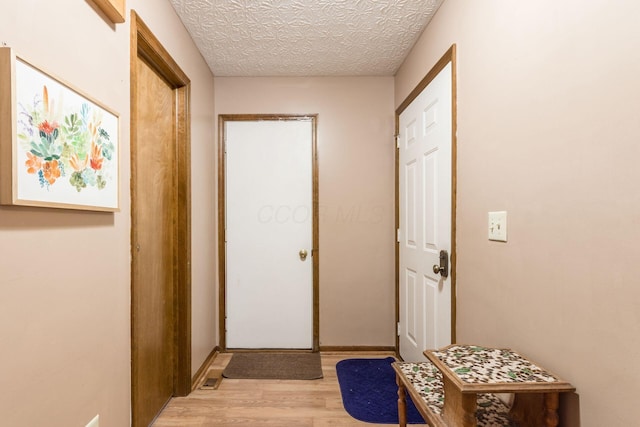 interior space with a textured ceiling and light hardwood / wood-style flooring