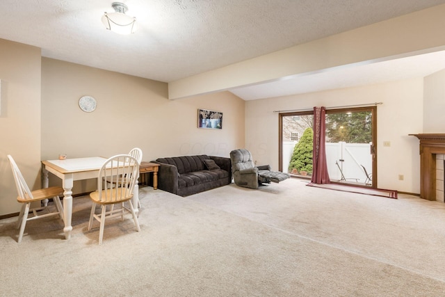 living room featuring carpet flooring, beam ceiling, a textured ceiling, and a tiled fireplace