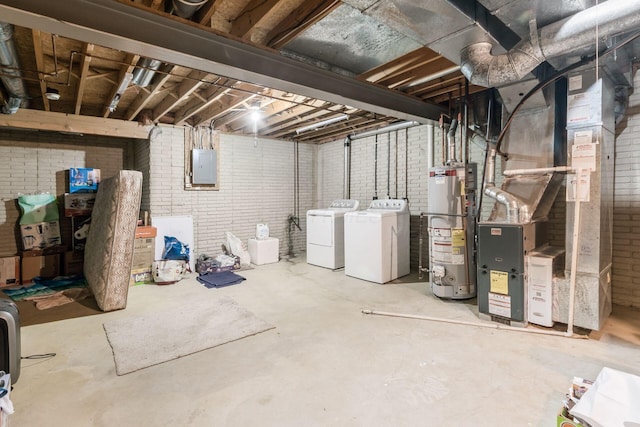 basement featuring electric panel, separate washer and dryer, brick wall, and gas water heater