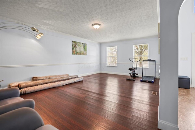 exercise room featuring wood-type flooring and a textured ceiling