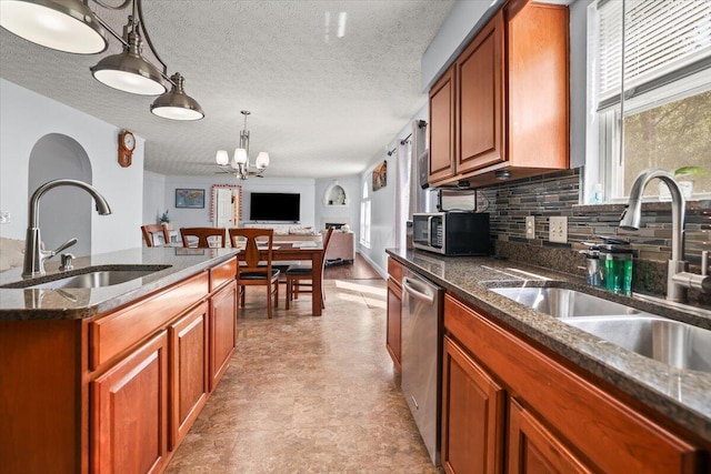 kitchen with plenty of natural light, sink, decorative light fixtures, and an inviting chandelier