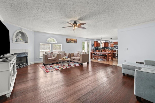 living room featuring a textured ceiling, ceiling fan, ornamental molding, and dark wood-type flooring