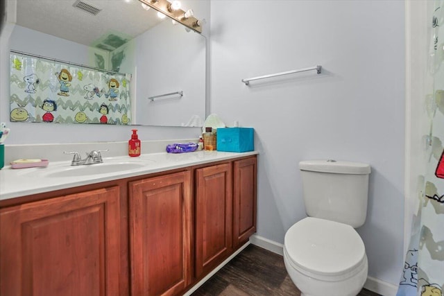 bathroom with vanity, wood-type flooring, a textured ceiling, and toilet