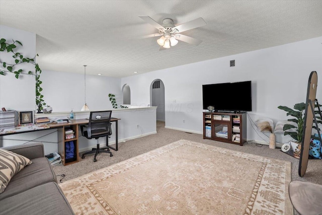 office area with carpet, ceiling fan, and a textured ceiling