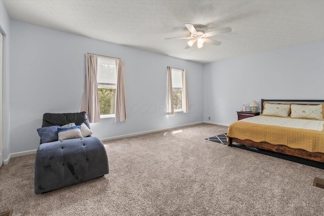 carpeted bedroom with ceiling fan and a textured ceiling