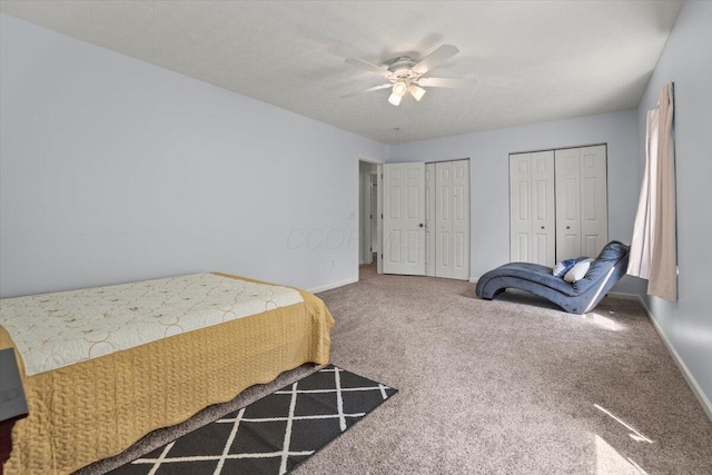 bedroom featuring carpet, ceiling fan, and multiple closets