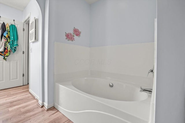 bathroom featuring wood-type flooring and a bathing tub