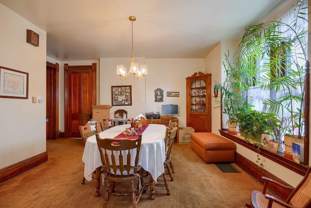 carpeted dining room with an inviting chandelier