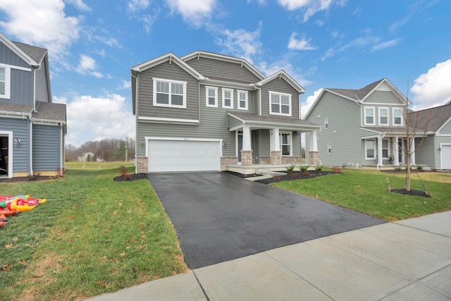 view of front of home featuring covered porch, a garage, and a front lawn