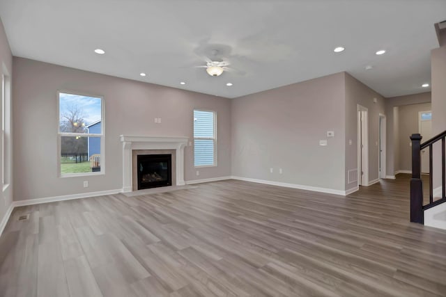 unfurnished living room with light hardwood / wood-style flooring and ceiling fan