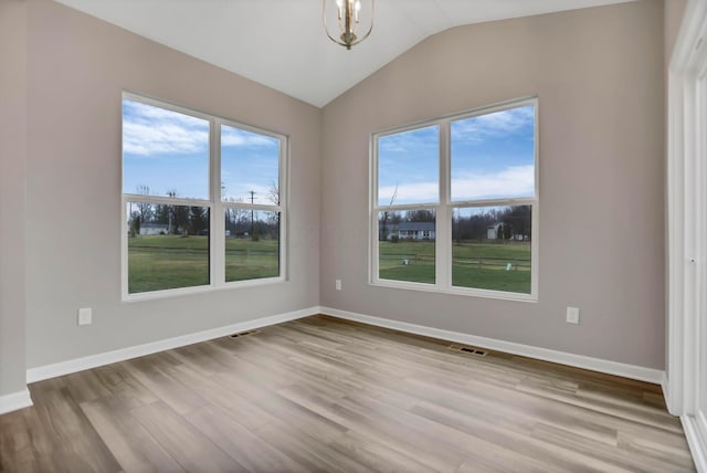 empty room featuring vaulted ceiling and light hardwood / wood-style flooring