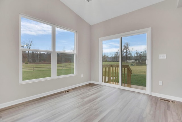 unfurnished room featuring light hardwood / wood-style floors and vaulted ceiling