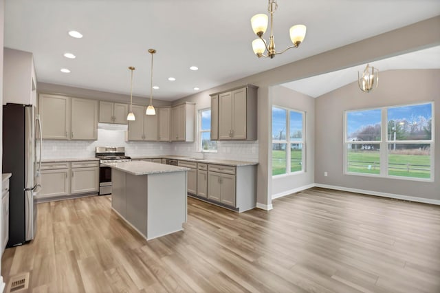 kitchen featuring pendant lighting, a center island, lofted ceiling, and stainless steel appliances