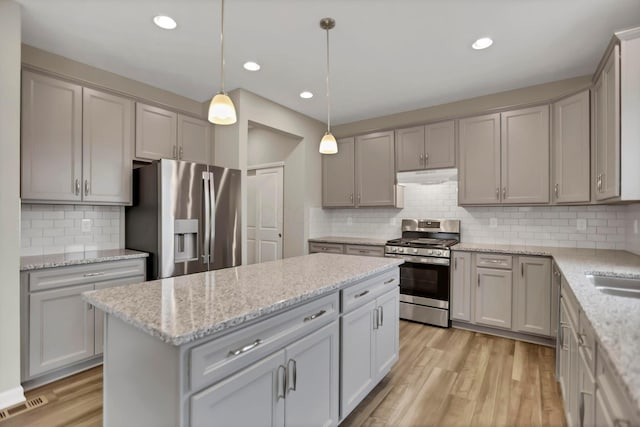 kitchen with gray cabinetry, a center island, pendant lighting, and appliances with stainless steel finishes