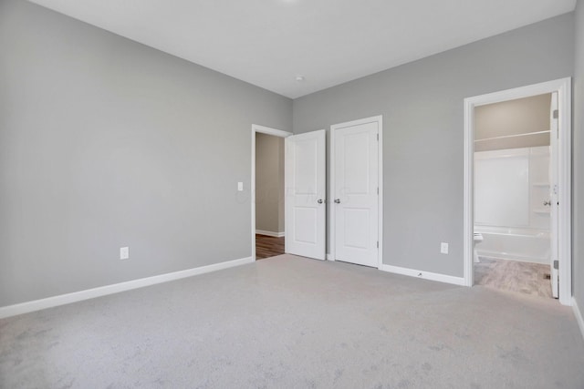 unfurnished bedroom featuring carpet and ensuite bath