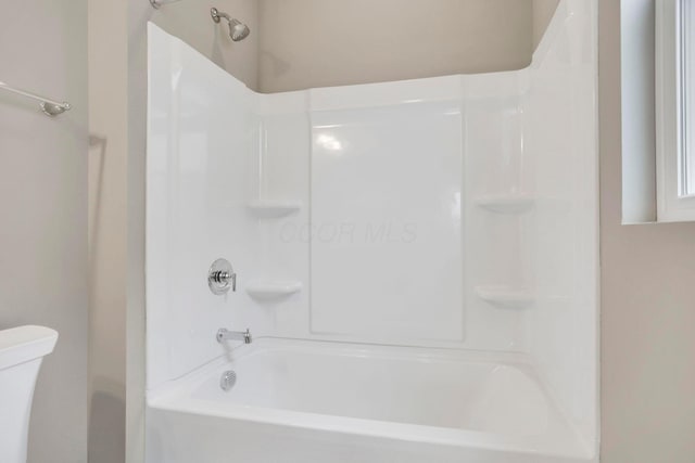 bathroom with shower / washtub combination and toilet