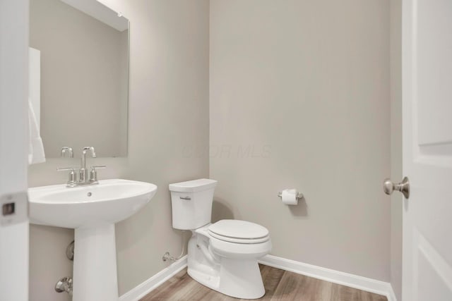 bathroom with hardwood / wood-style flooring and toilet