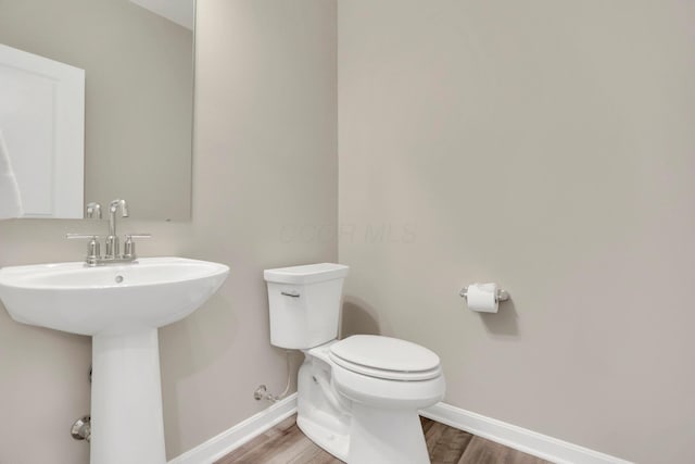 bathroom featuring hardwood / wood-style flooring, toilet, and sink