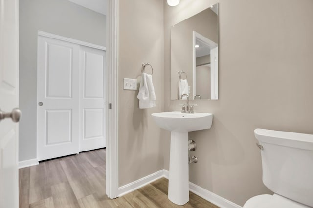 bathroom with hardwood / wood-style floors and toilet