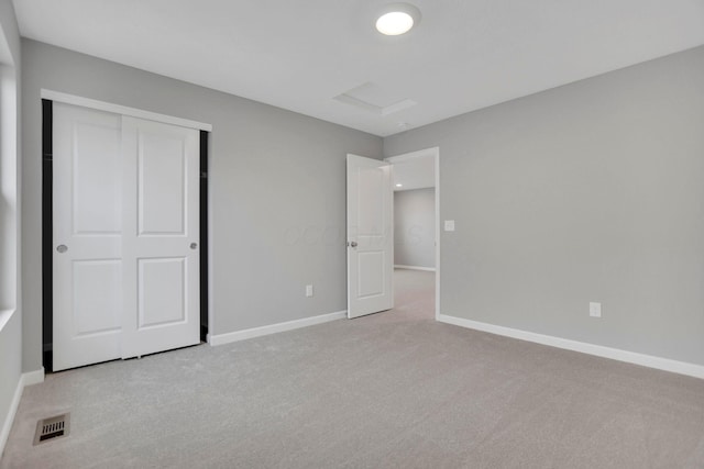 unfurnished bedroom featuring light carpet and a closet