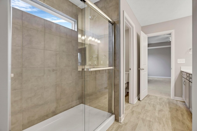 bathroom featuring vanity, a shower with shower door, and toilet