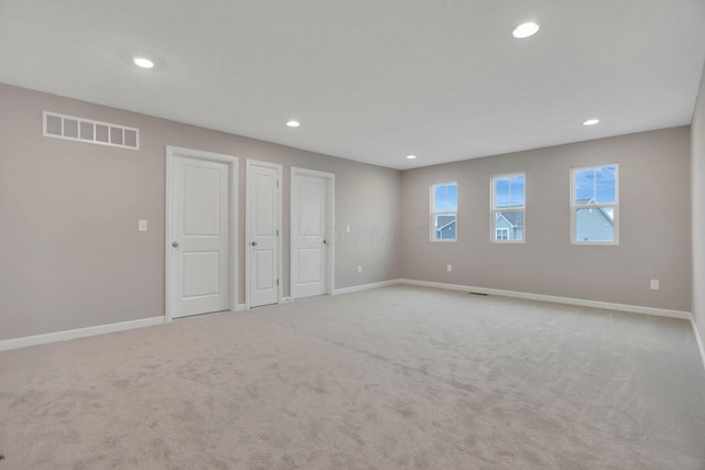 interior space featuring light carpet and multiple closets