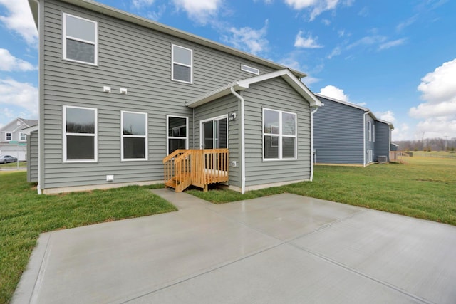 rear view of property featuring a yard and a patio