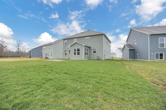 back of house featuring central air condition unit and a yard