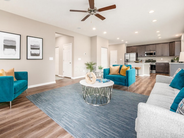 living room with hardwood / wood-style floors and ceiling fan