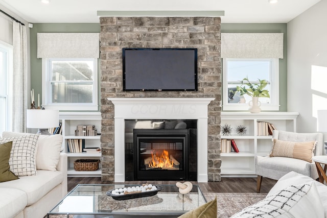 living room with a large fireplace and dark hardwood / wood-style flooring